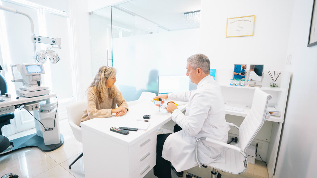 Control post-cirugía: el médico explica con un modelo del ojo en el consultorio